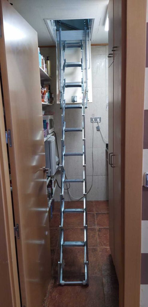 Instalación de escalera escamoteable en almacén de peluquería